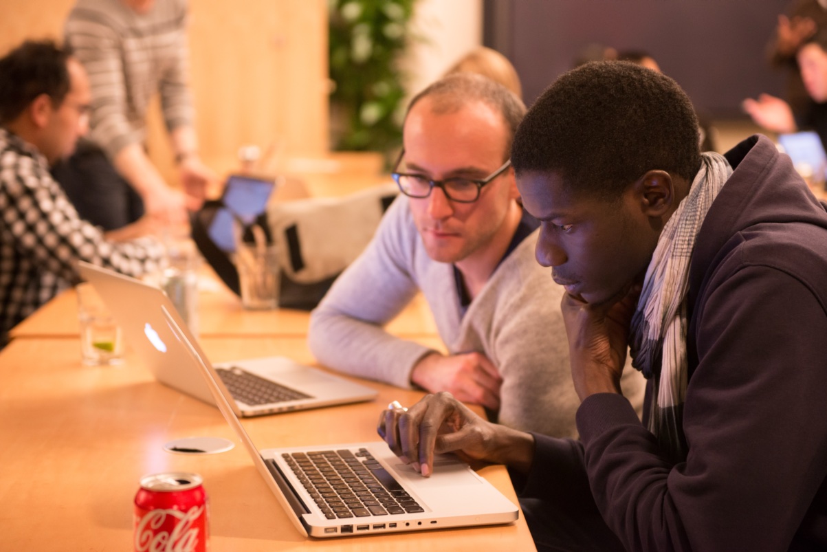 Two founders working through a problem on a laptop during a Founder Institute session